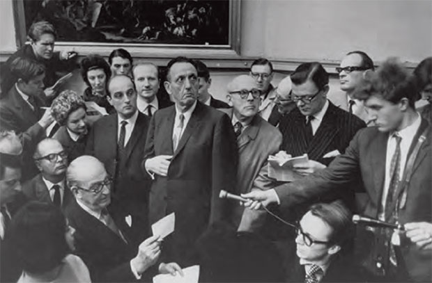 Industrialist Norton Simon, hand on his chest is surrounded by members of of the press and fellow collectors at Christie's King Street on 19 March 1965