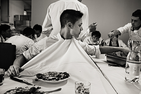 A waiter keeps his shirt clean during a staff meal at Osteria Francescana. Photograph by Per-Anders Jörgensen, from Eating with the Chefs