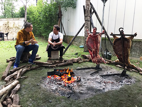 Andre Chiang (left) and Rodolfo Guzmán chat beside two roasting lambs in Taipei, during Rodolfo's recent Asian tour