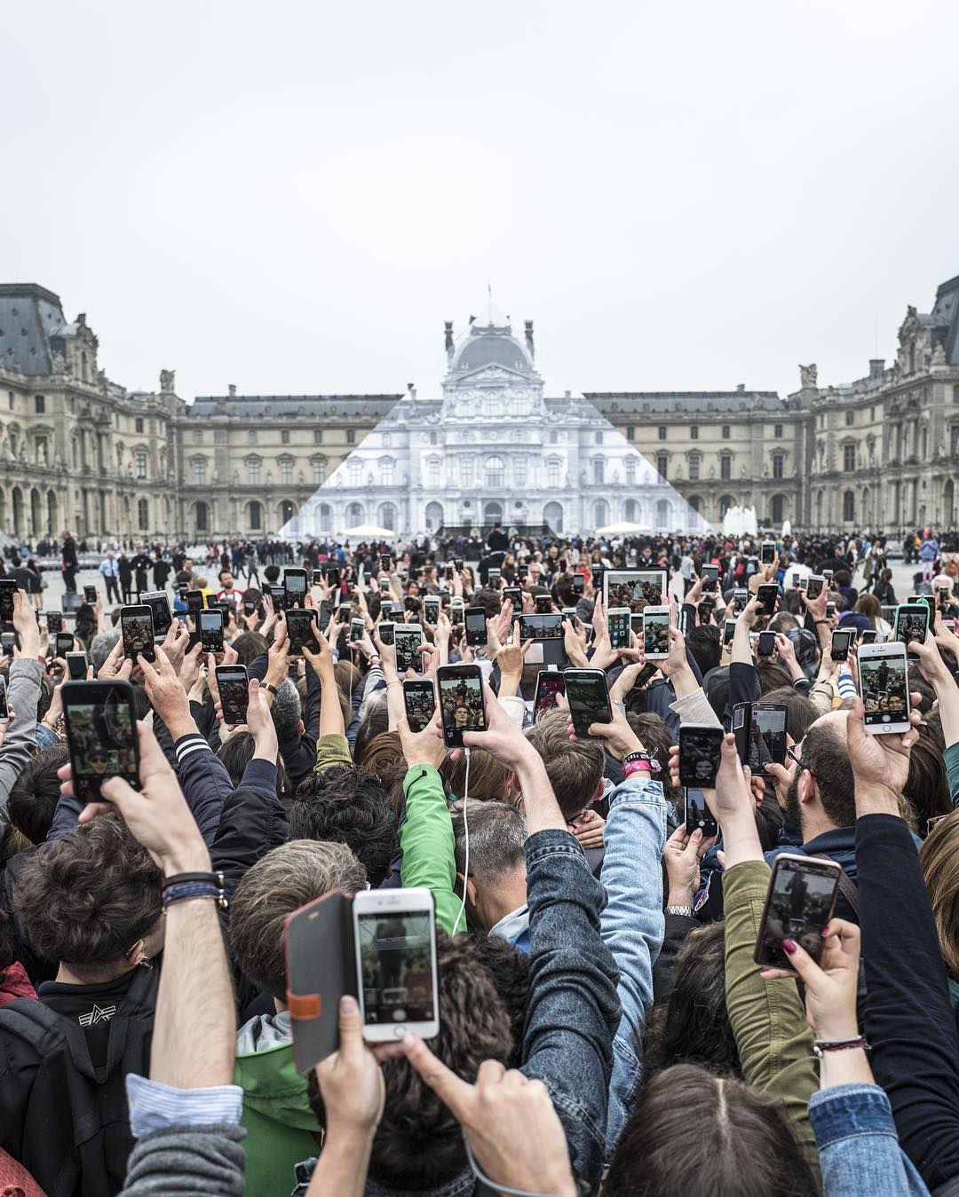 Louvre visitors take selfies beside the Pyramid