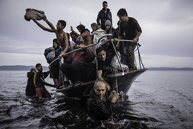 Sergey Ponomarev November 16, 2015. Migrants arrive by a Turkish boat near the village of Skala, on the Greek island of Lesbos. The Turkish boat owner delivered some 150 people to the Greek coast and tried to escape back to Turkey; he was arrested in Turkish waters. Series: Europe Migration Crisis 2015. © Prix Pictet Space