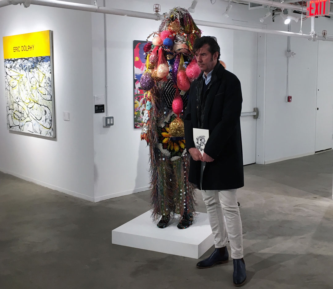Stefan Sagmeister with Nick Cave's Soundsuit, 2006, now on view at Phillips New York