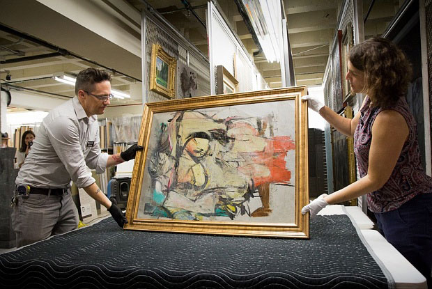 The recovered Willem de Kooning painting Woman-Ochre, held by University of Arizona Museum of Art staff (Photo: Courtesy of the University of Arizona)