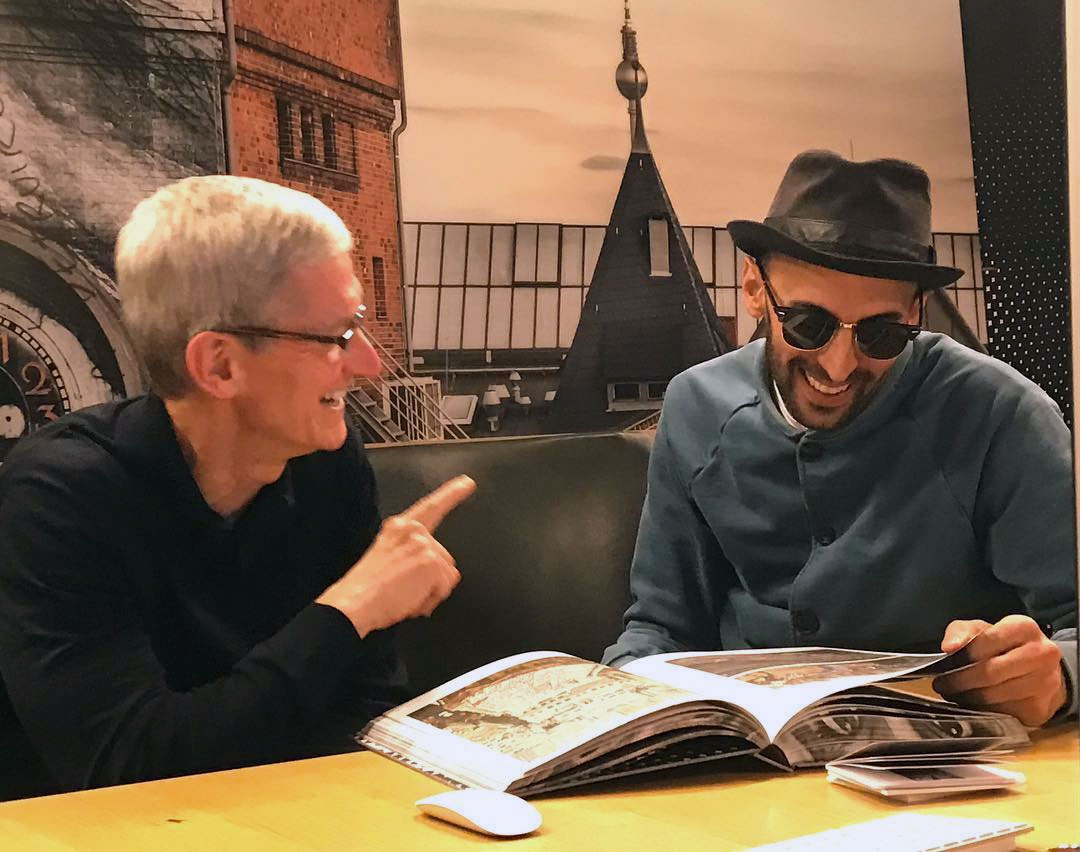 Tim Cook and JR browse through a copy of JR: Can Art Change the World? Image courtesy of Marco Berrebi's Instagram