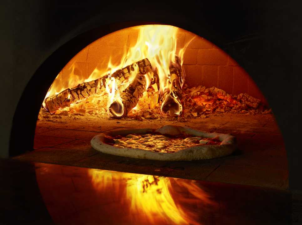 A pizza in a wood-fired oven. All photographs by Nathan Myhrvold / The Cooking Lab, LLC.